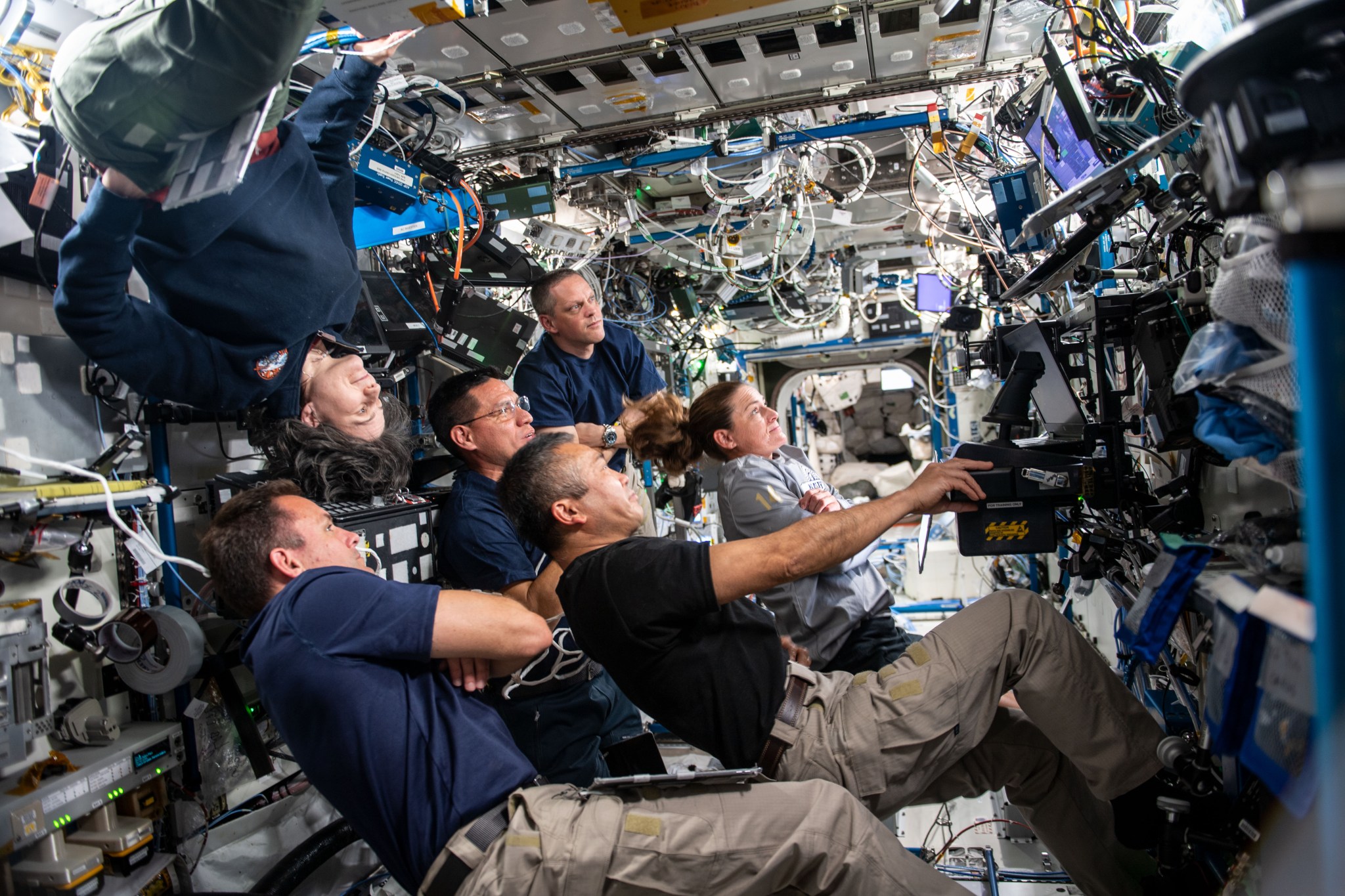 Expedition 68 crew members during an evening conference with the ground