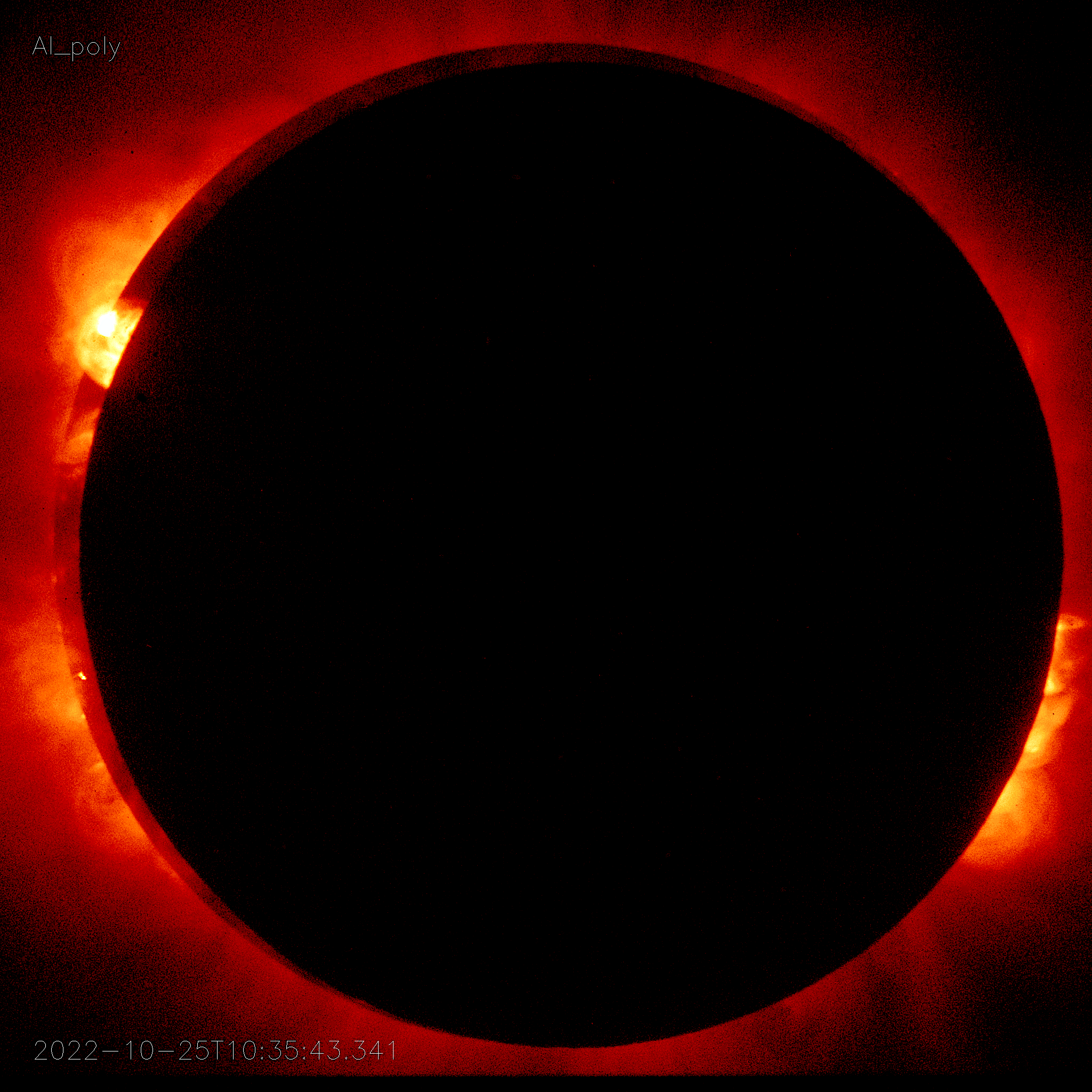 A photo showcasingHinode view of the annular Solar Eclipse from Orbit. The background is red and the sun is covered a black circle.