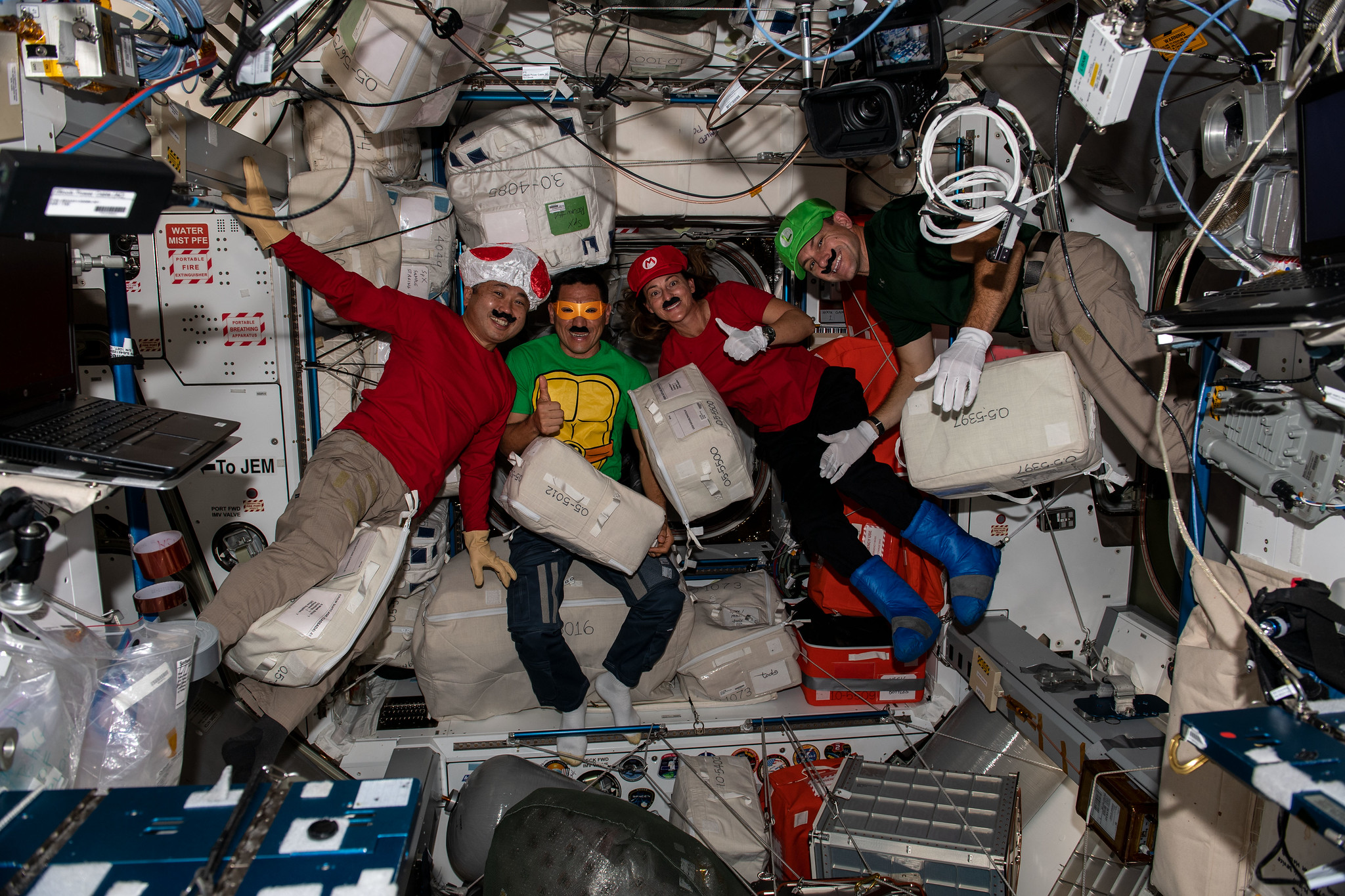 image of astronauts celebrating Halloween dressed up as video game and cartoon characters aboard the International Space Station.