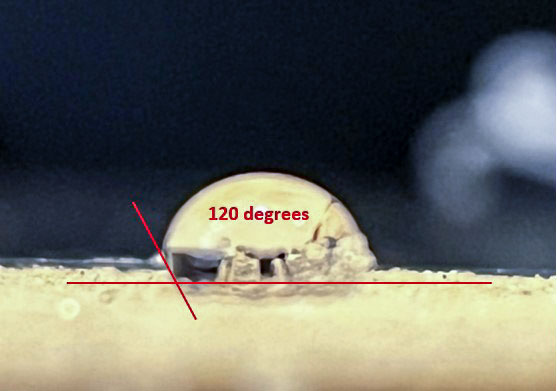 Image of a water droplet on hydrophobic sand stands up and has a more rounded shape compared to normal hydrophilic sand.