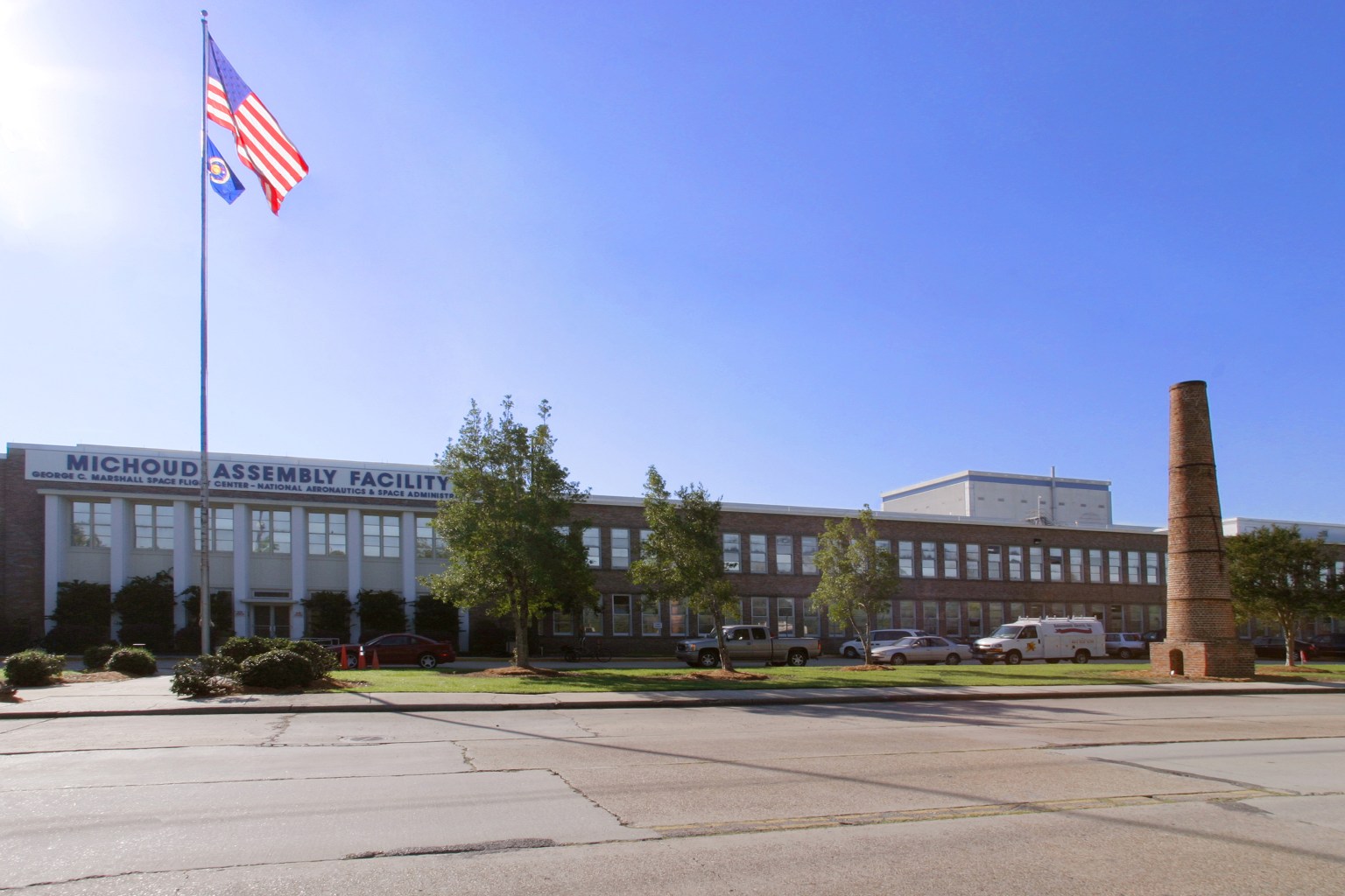 The outside of of NASA's Michoud Assembly Facility in New Orleans with an American flag on the left side of the photo.