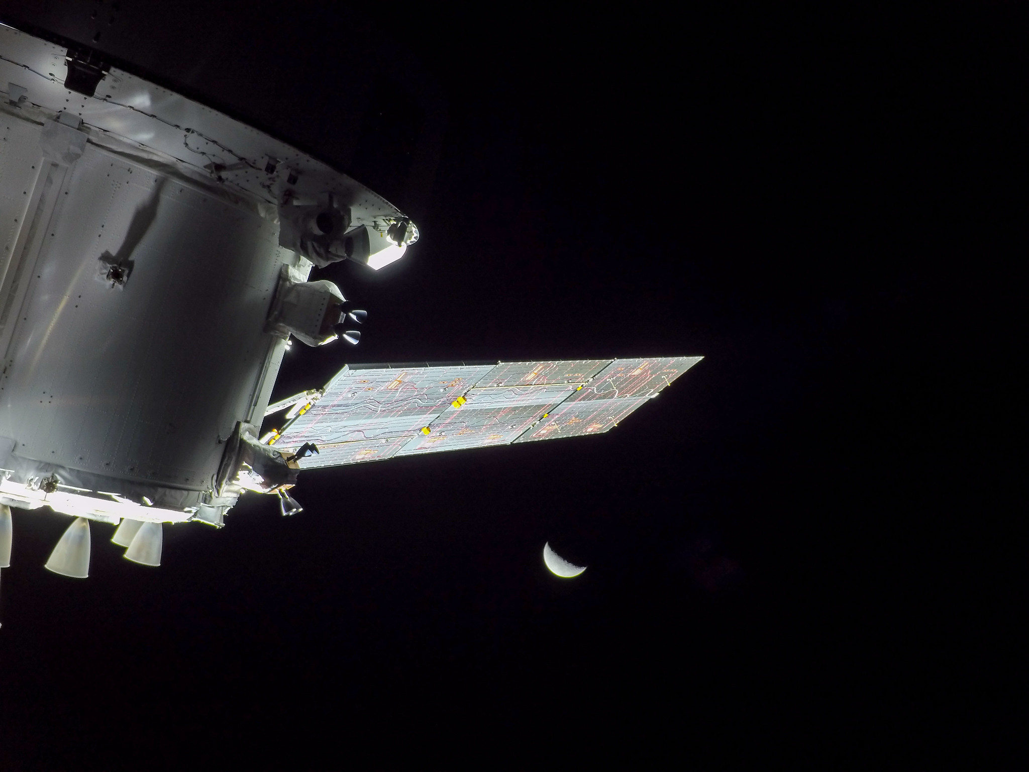 A spacecraft is seen in space with the Moon in the distance