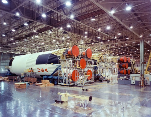 The photograph shows Saturn V S-IC flight stages being assembled in the horizontal assembly area at the MAF.