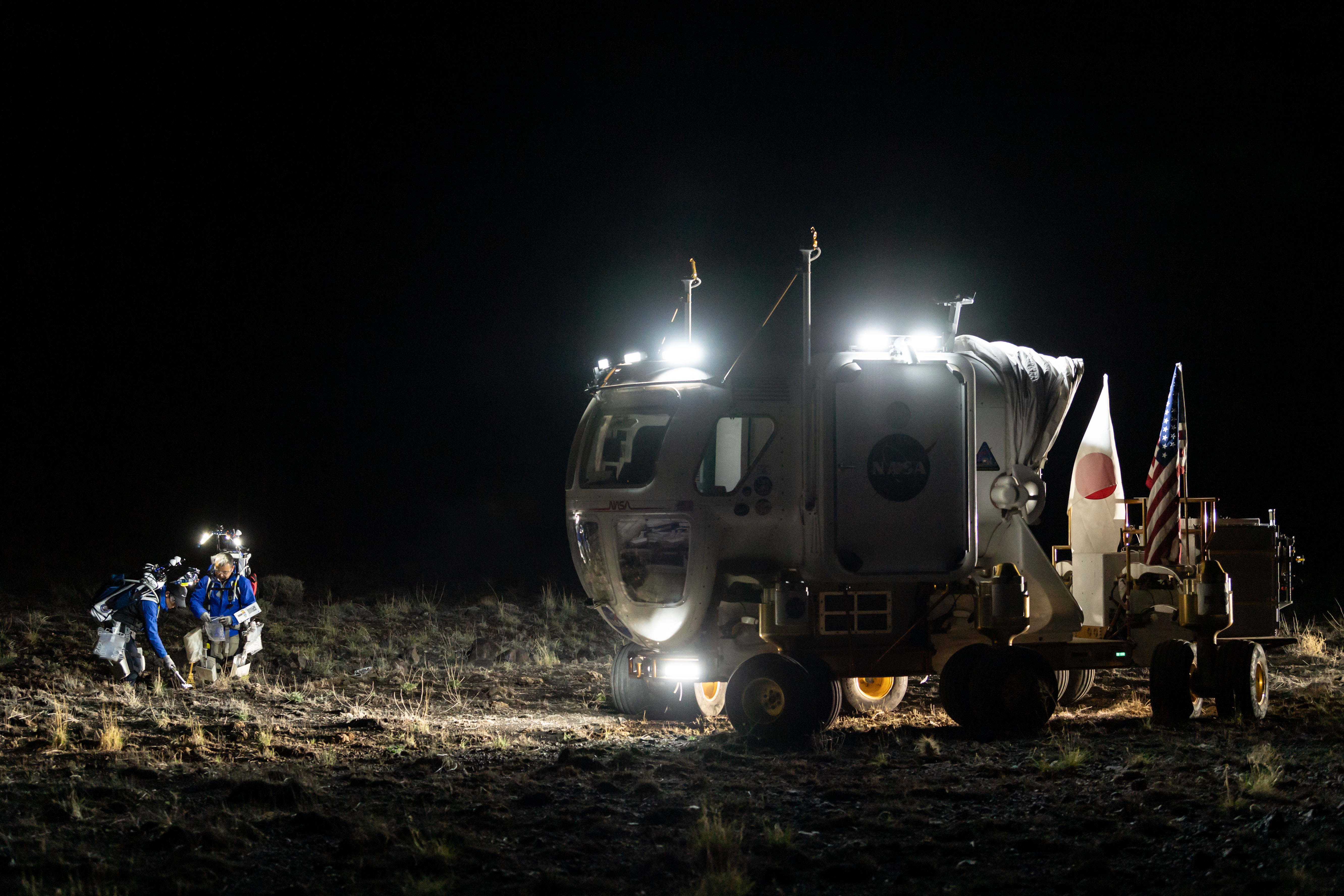D-RATS JAXA crew members Akihiro Hoshide and Yusuke Yamasaki collect samples during a simulated moonwalk using light from the rover and their backp...