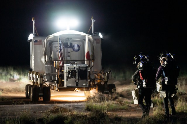 D-RATS NASA crew members Jessica Meir and Sarah Shull walk behind the rover during a simulated moonwalk.