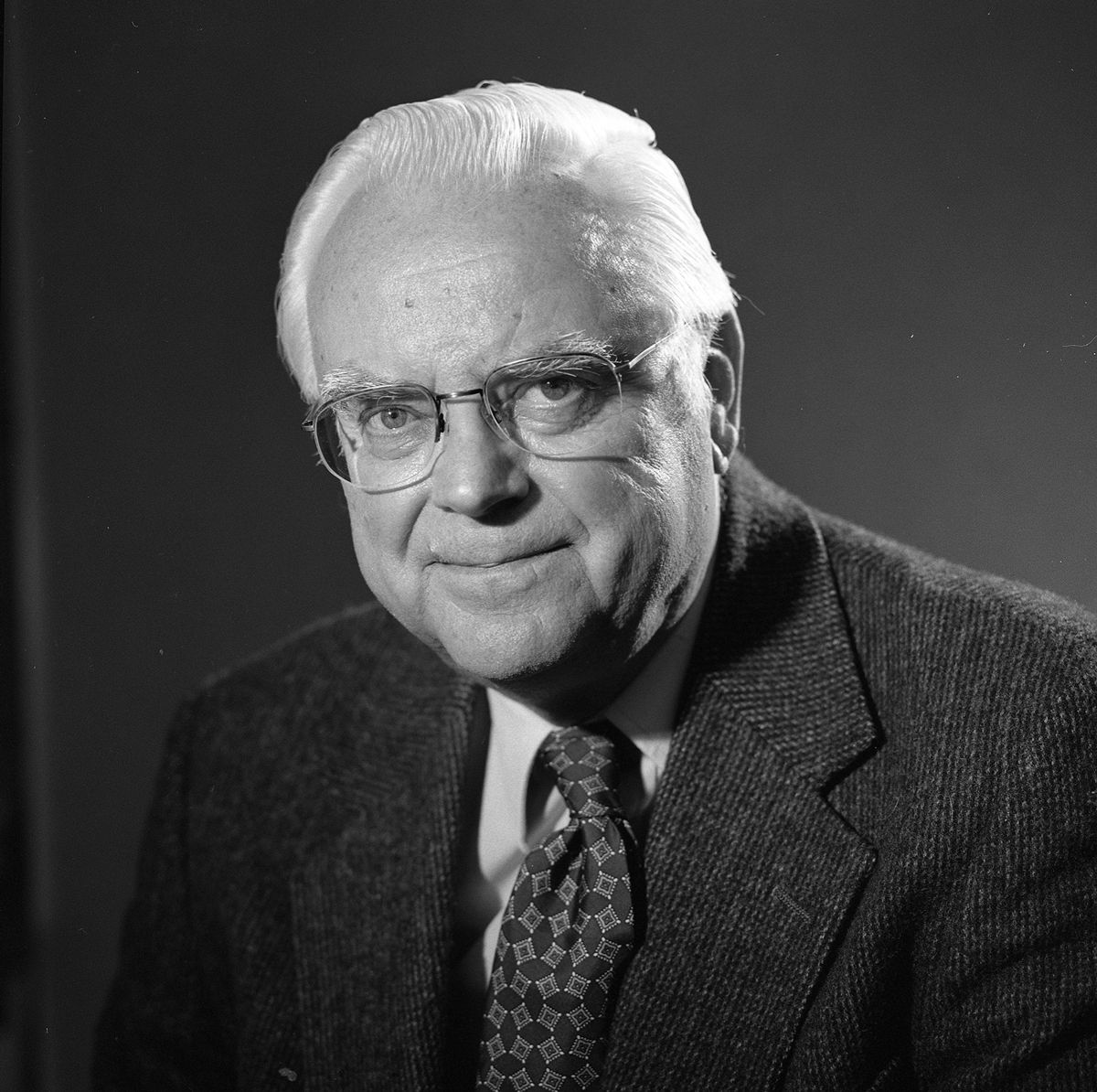 Black and white portrait of Dr. Frank Drake, wearing a suit and tie, and wearing glasses.