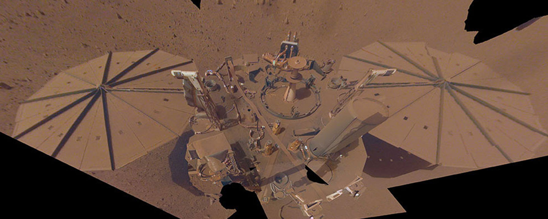 A thick layer of dust can be seen on the InSight lander and its solar panels in the image.