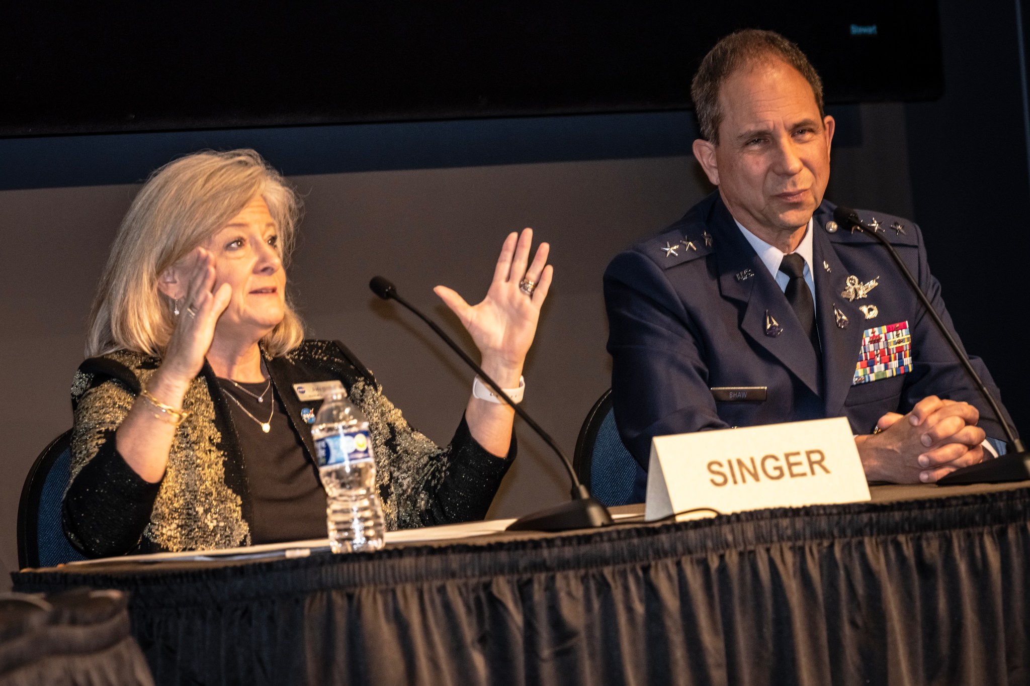 NASA Marshall Space Flight Center Director Jody Singer, left, and Lt. Gen. John Shaw, deputy commander of United States Space Command, right, sit a table to present at the 2022 Wernher von Braun Symposium