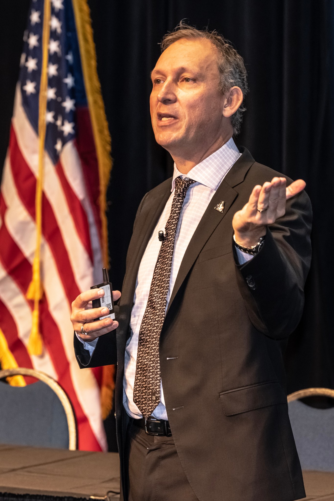 Thomas Zurbuchen gives a speech for 2022 Wernher von Braun Symposium in front of an American flag.