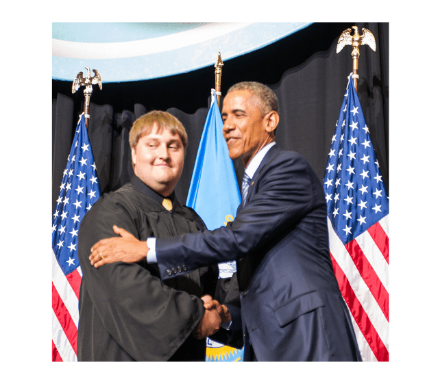 Space Grant student in Graduation Attire Shaking Hands with President Obama