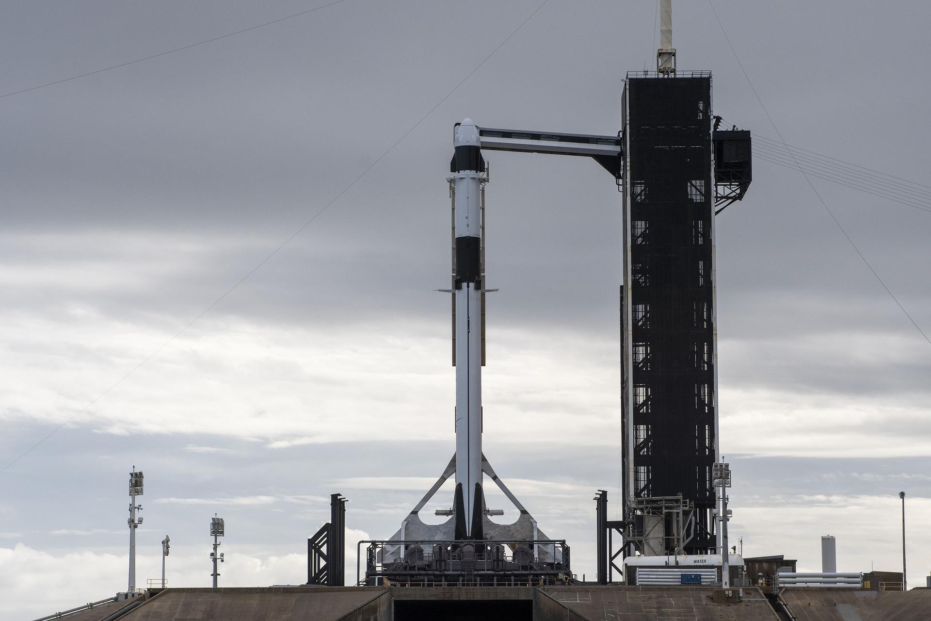 A SpaceX Falcon 9 rocket, with the company’s Dragon cargo spacecraft atop, is raised to a vertical position at NASA Kennedy Space Center’s Launch Complex 39A on Nov. 21, 2022. 