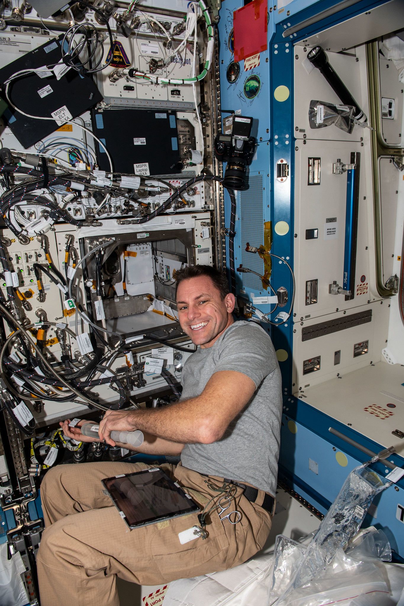 image of an astronaut filling the water reservoirs of a plant experiment