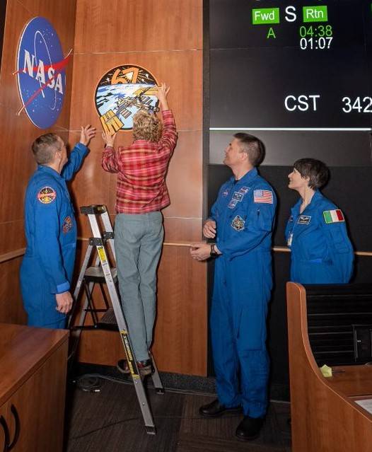 Lisa Prendergast, research payload operations integration specialist, installs the SpaceX Crew-4 astronauts’ mission patch.