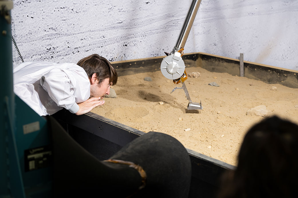 A JPL engineer examines the 3D-printed titanium scoop 