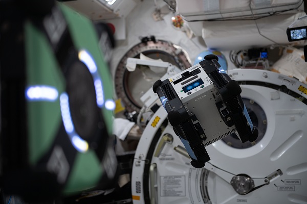image of two floating cube-sized robots inside the space station