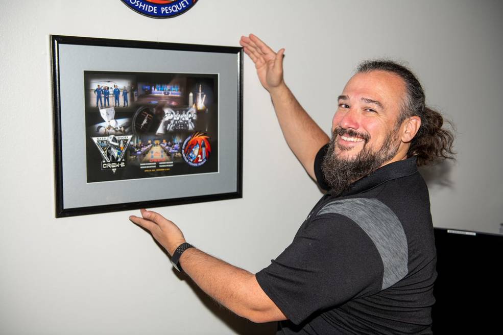 Adam Butt, CCP launch vehicle chief engineer, hangs the Crew-2 mission plaque during a newly established ceremonial tradition at the HOSC, M203.