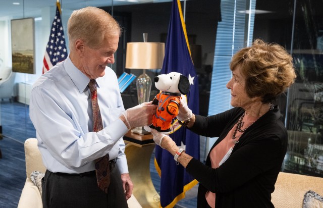 NASA Administrator Bill Nelson, left, is seen with Jeannie Schulz, widow of Peanuts gang creator Charles M. Schulz, right, holding the Artemis I Snoopy zero gravity indicator, Wednesday, April 5, 2023, during a visit to the Mary W. Jackson NASA Headquarters building in Washington.