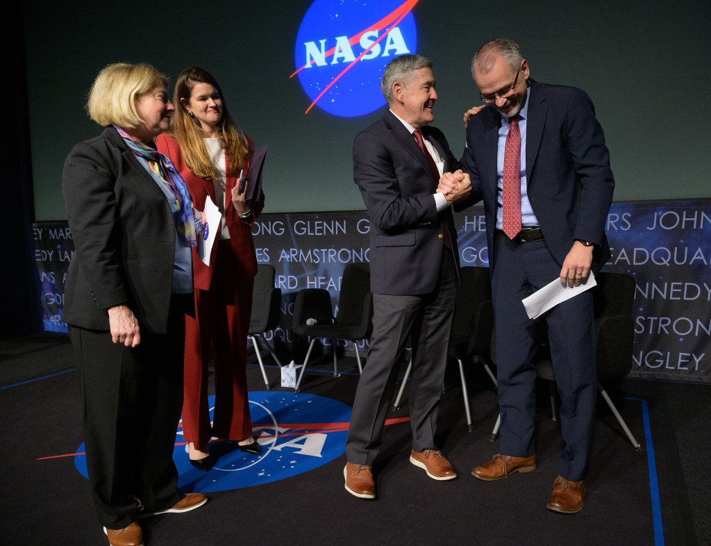 NASA Associate Administrator Bob Cabana, 3rd from left, shakes hands with Incoming NASA Associate Administrator Jim Free, right, as NASA Deputy Administrator Pam Melroy, left, and NASA Deputy Associate Administrator Casey Swails look on at the conclusion of a NASA town hall event, Tuesday, Dec. 12, 2023, at the NASA Headquarters Mary W. Jackson Building in Washington.