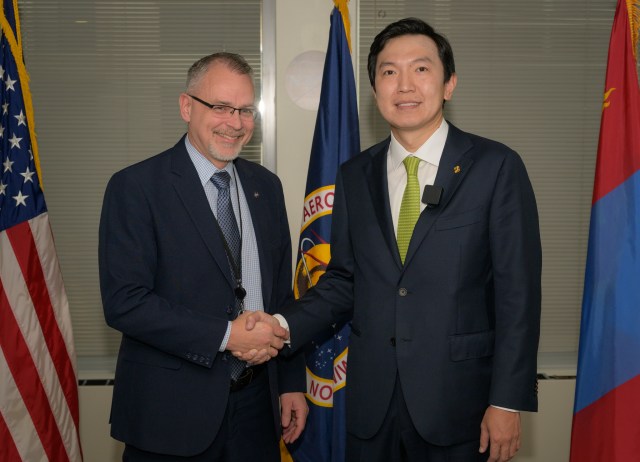 Associate Administrator Jim Free, left, and Mongolian Minister of Digital Development and Communications Nyam-Osor Uchral, shake hands ahead of a meeting.