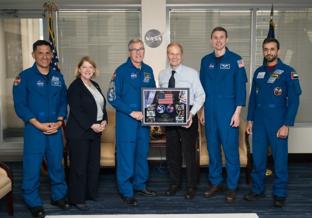 From left to right, Expedition 69 NASA astronaut Frank Rubio, NASA Deputy Administrator Pam Melroy, NASA astronaut Stephen Bowen, NASA Administrator Bill Nelson, NASA astronaut Warren Hoburg, and UAE (United Arab Emirates) astronaut Sultan Alneyadi, pose for a photo with a montage from their mission, Tuesday, March 19, 2024 at the Mary W. Jackson NASA Headquarters building in Washington.