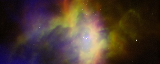 A colorful composite image of a large gas cloud flecked with white dots. RCW 36 is a mustard yellow, burnt orange, royal blue, and violet cloud.