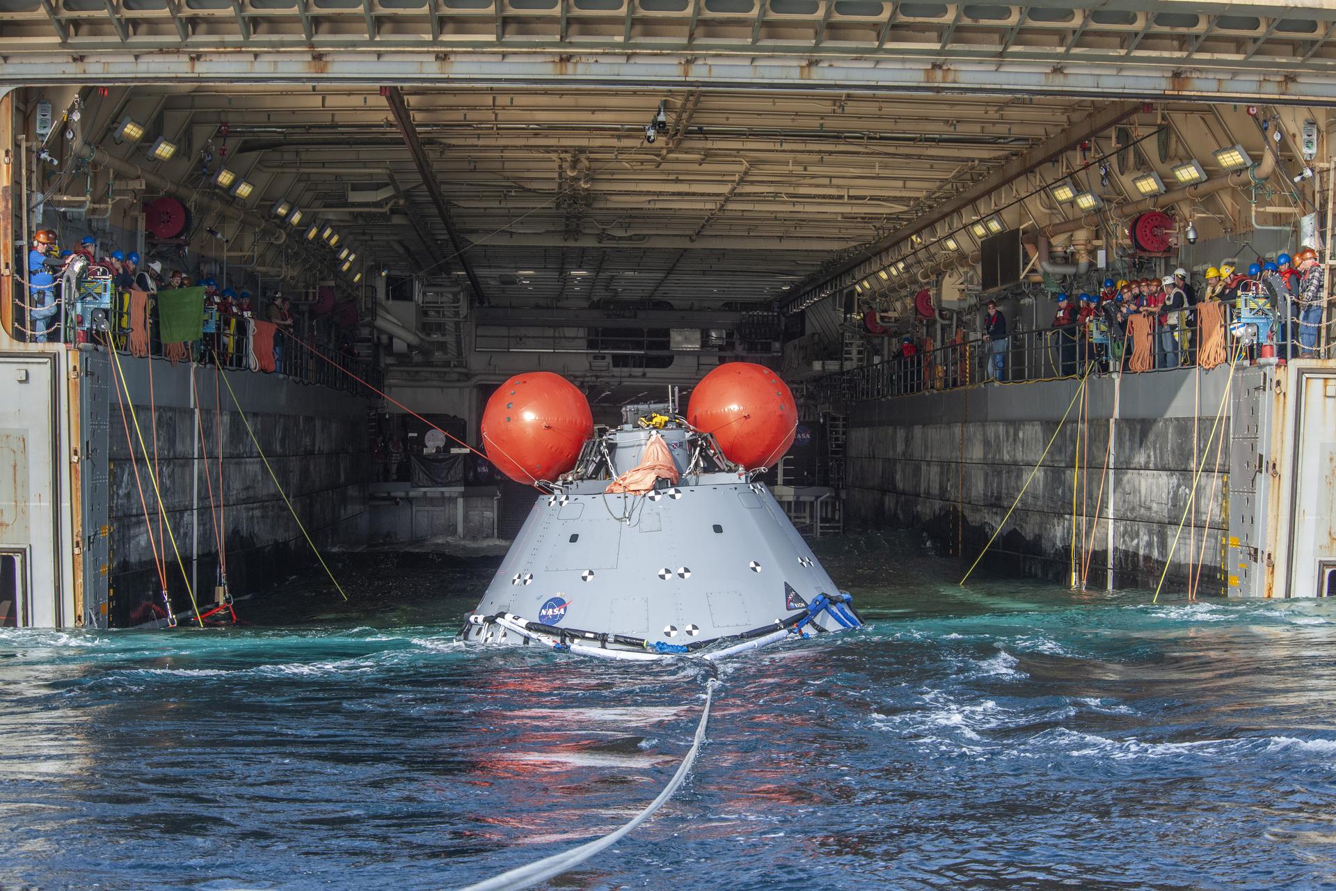 NASA's Landing and Recovery Team practices bringing a mock Orion capsule into the well deck of the USS Portland (LPD 27) ahead of the Artemis I Orion splashdown slated for Dec. 11.