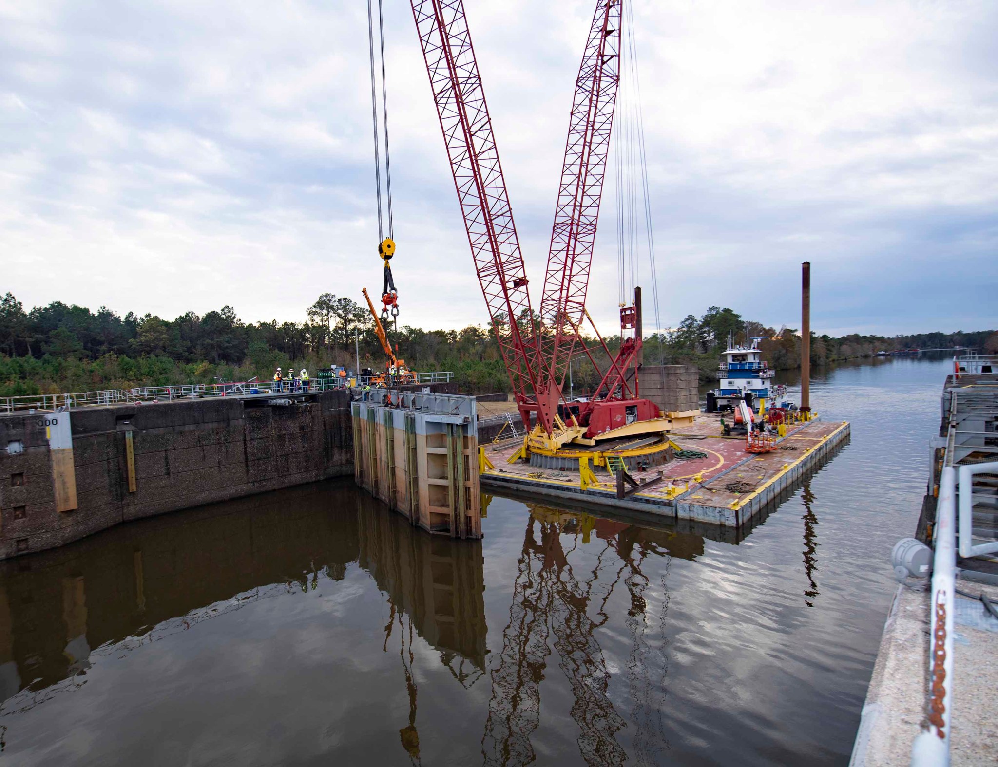 Crews install steel structures known as stop logs at the waterway to NASA’s Stennis Space Center