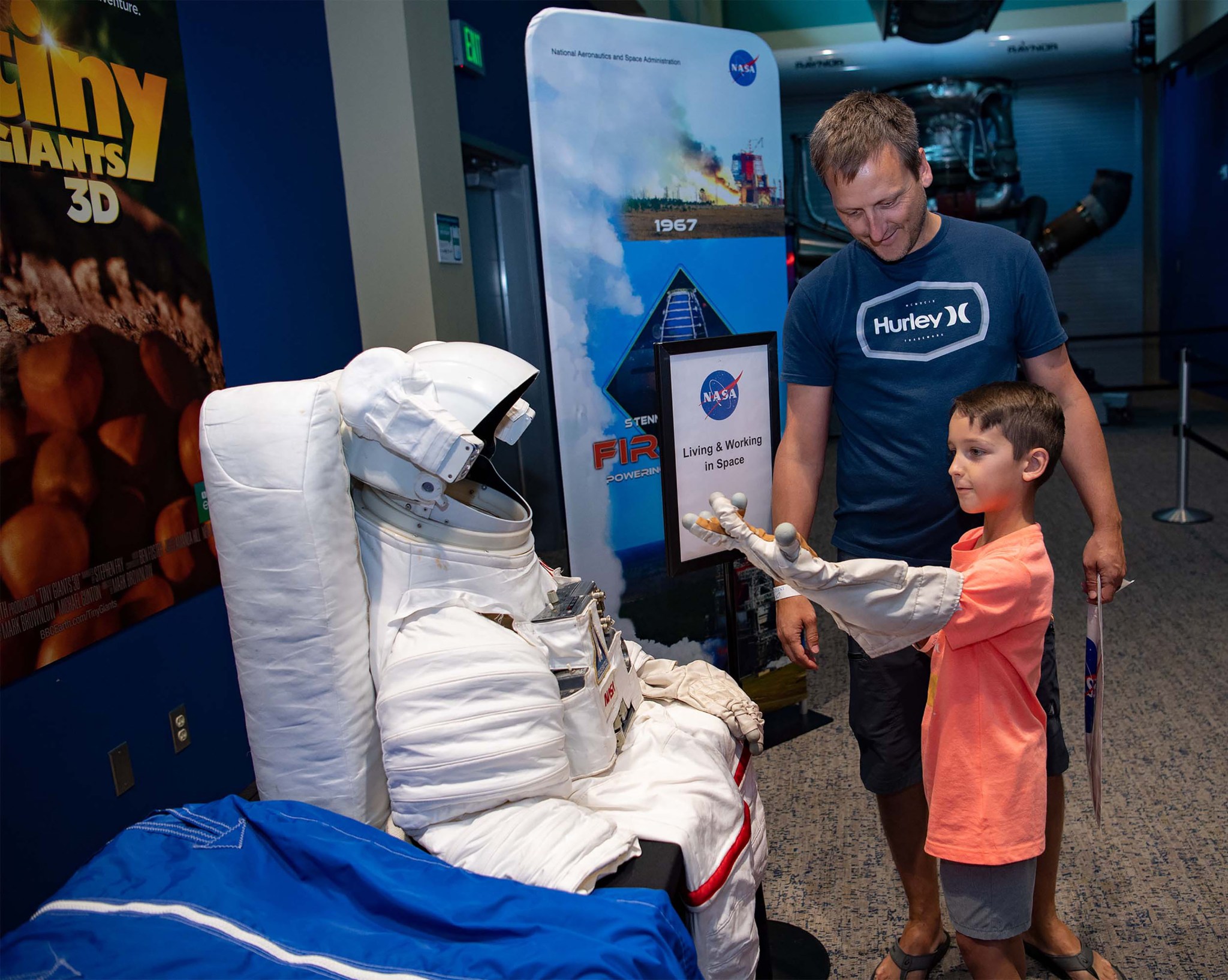 A young visitor tries out the astronaut glove exhibit at INFINITY Science Center