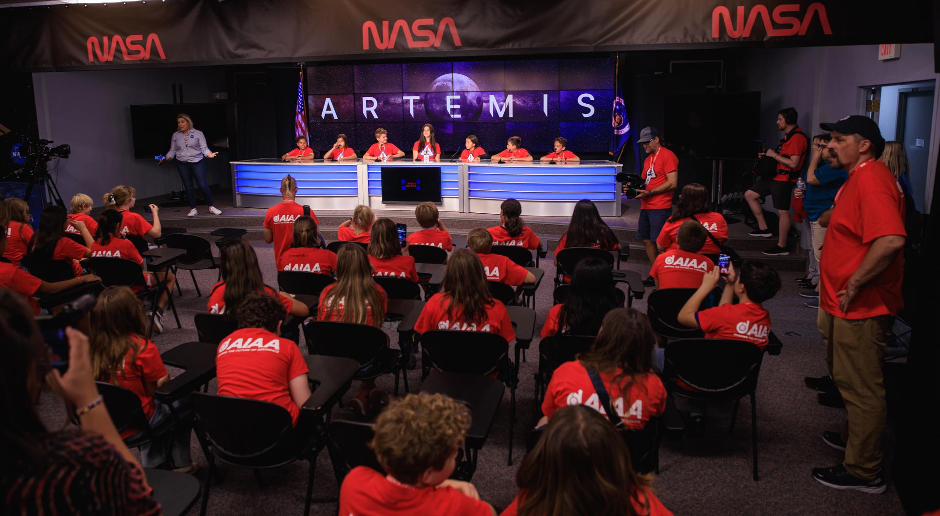 A group of students and their chaperones gather in the John Holliman Auditorium of the News Center to simulate a news conference during a tour of NASA’s Kennedy Space Center in Florida on Oct. 6, 2022.