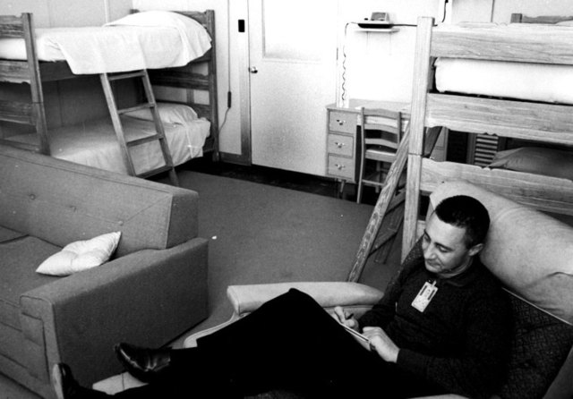 Astronaut Gus Grissom relaxes in the crew quarters at Hangar S.