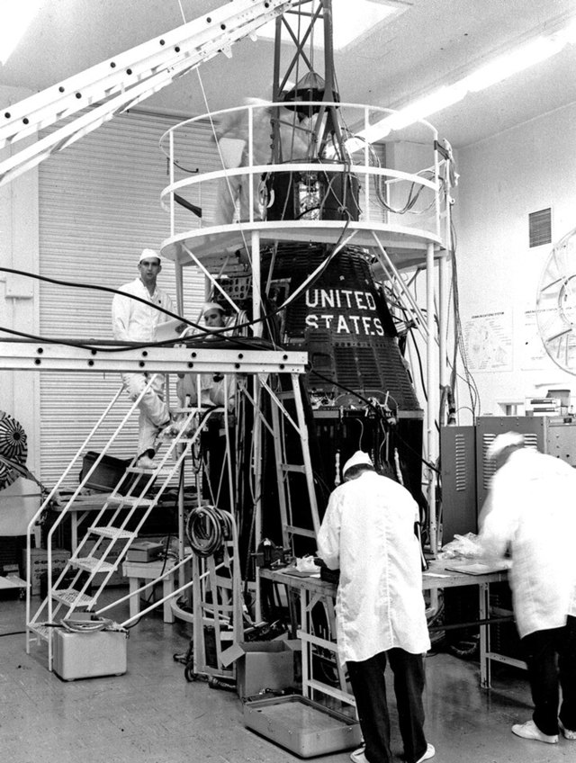 Technicians work on the Mercury capsuler for the Mercury-Atlas 7 mission.