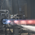 An engine test with a stream of blue to red flames.