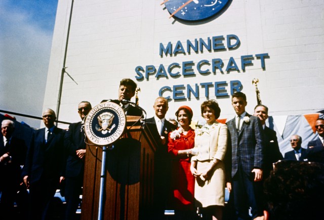 President John F. Kennedy stands at a podium in front of the Manned Spacecraft Center to honor astronaut John Glenn, Jr.