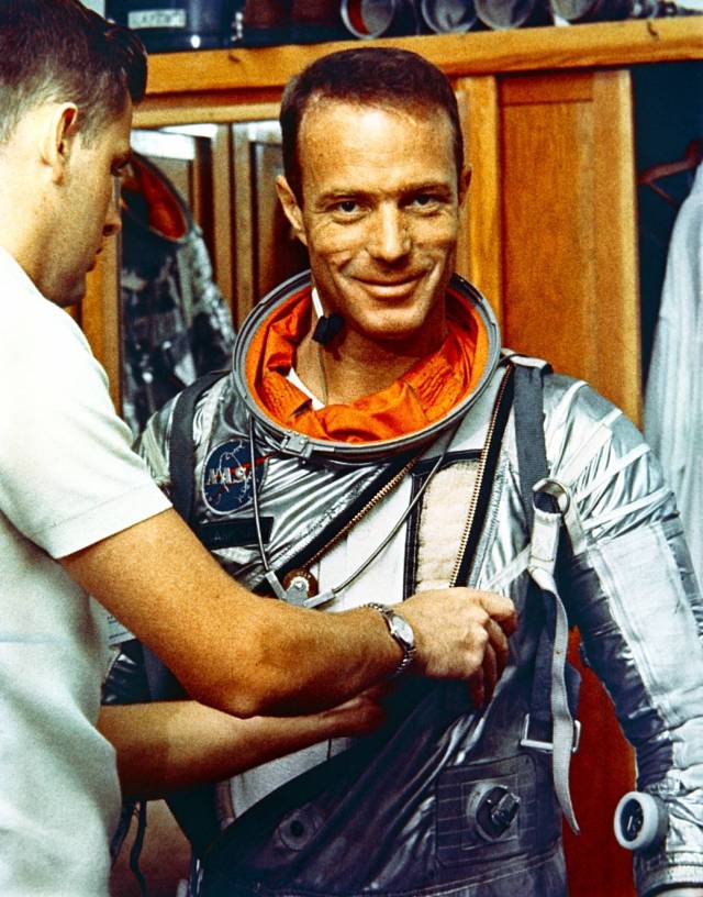 Astronaut M. Scott Carpenter smiles for the camera is he gets suited by suiting technician Al Rochford