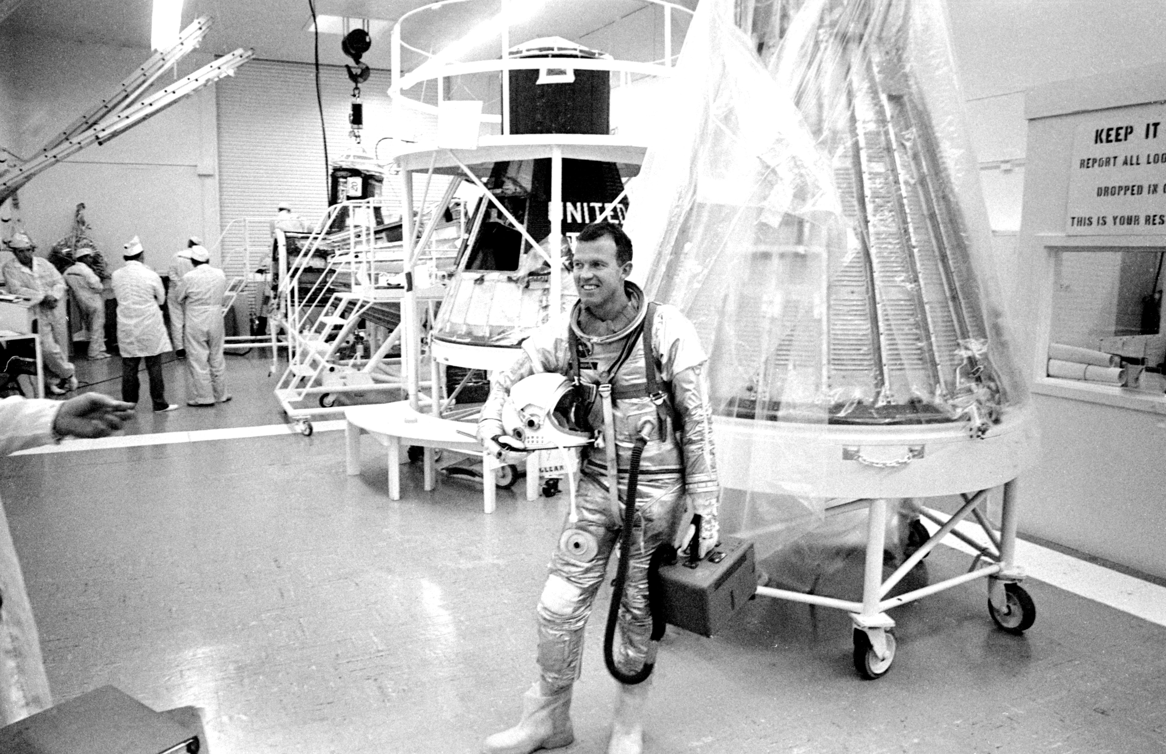 Gordon Cooper holds his helmet as he completes simulated flight tests for his Mercury-Atlas 9 mission