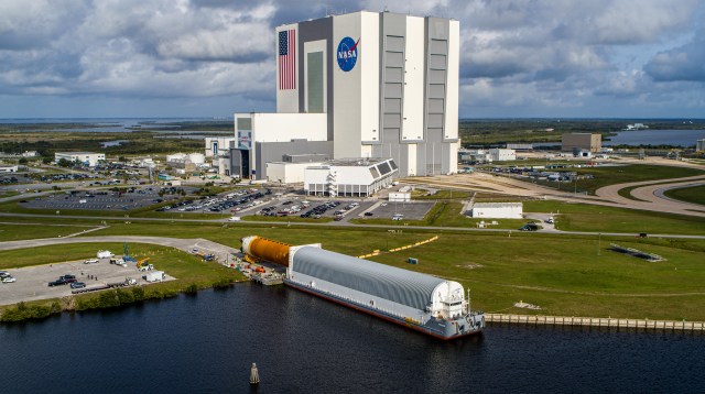 In this aerial view, the massive 212-foot long Space Launch System (SLS) core stage is shown being offloaded from the Pegasus Barge on April 29, 2021, after arriving at NASA’s Kennedy Space Center in Florida.