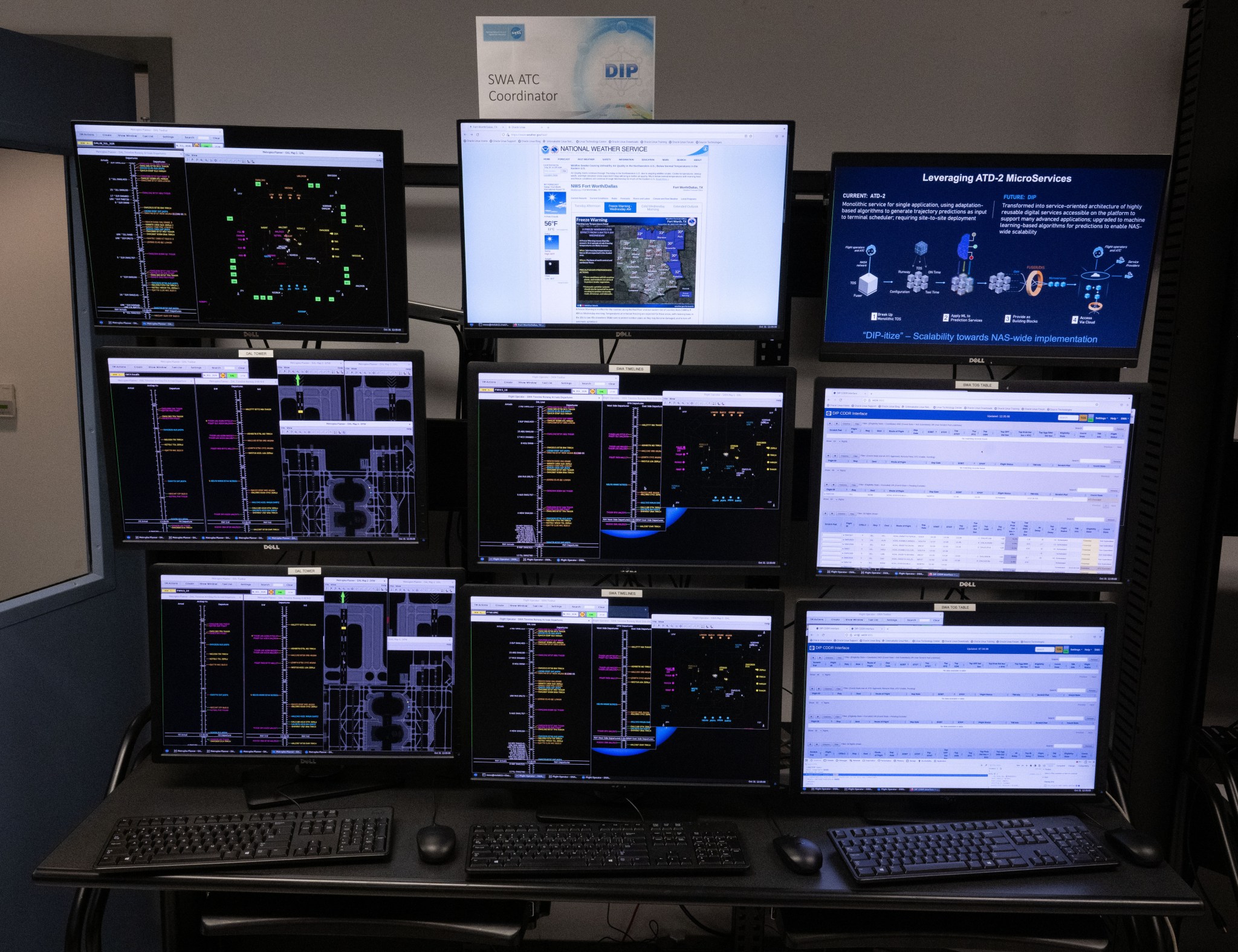 Nine active computer monitors arranged in a grid, all showing different types of data and readouts. 