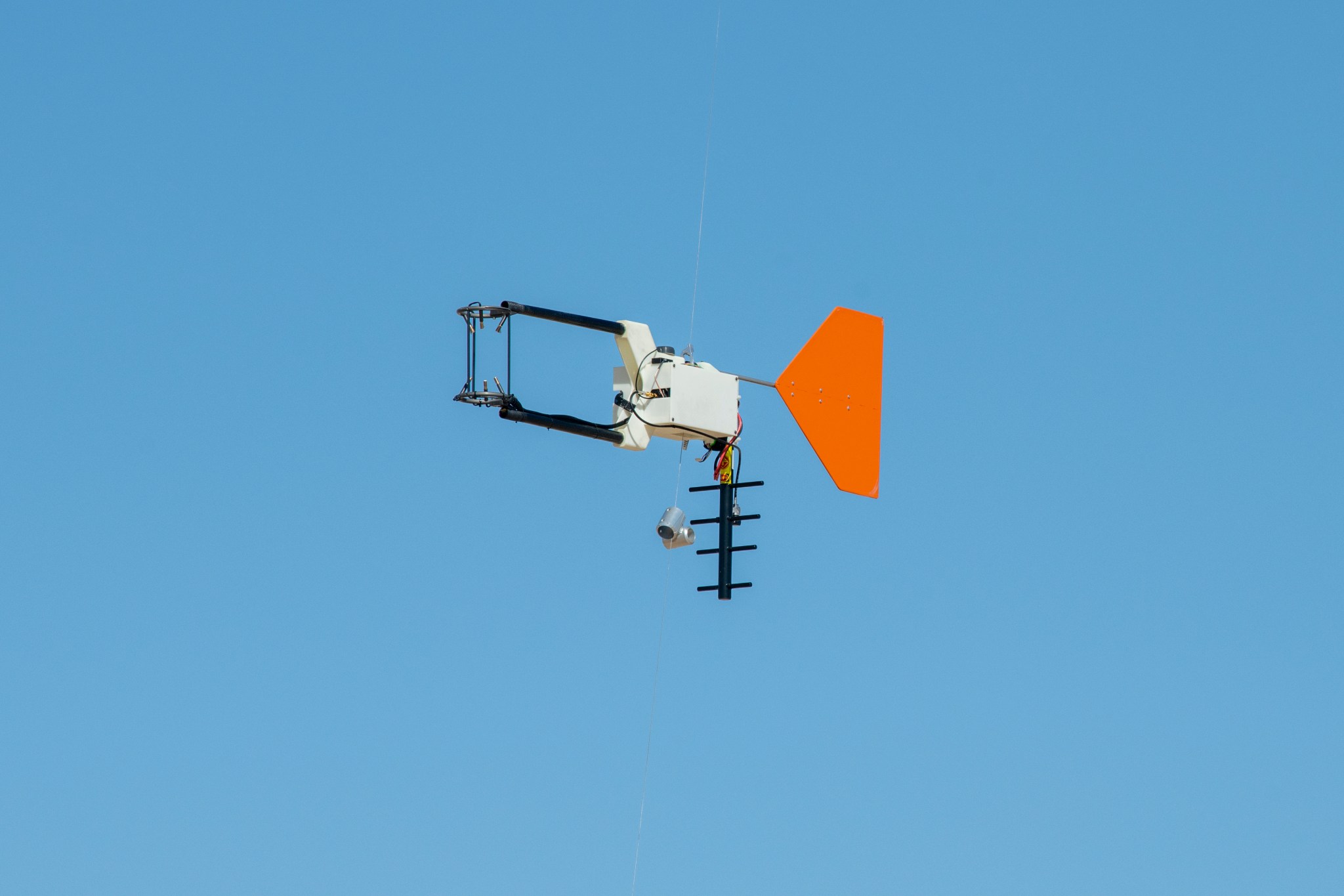 Weather instrumentation is shown in flight against a blue sky.
