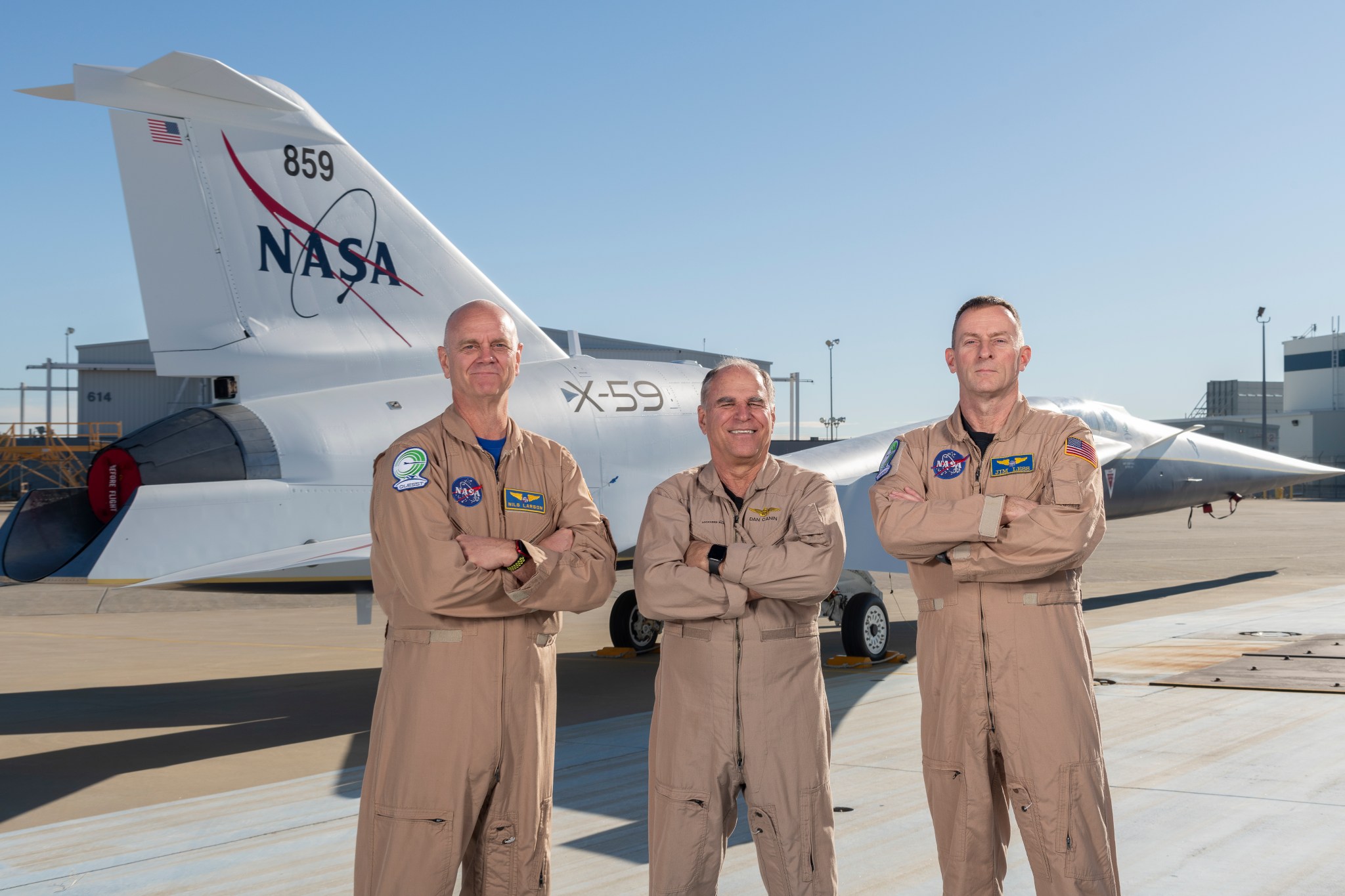 In this photo, NASA research pilot Nils Larsen, Lockheed Martin test pilot Dan “Dog” Canin, and NASA research pilot Jim Less stand in front of the X-59.