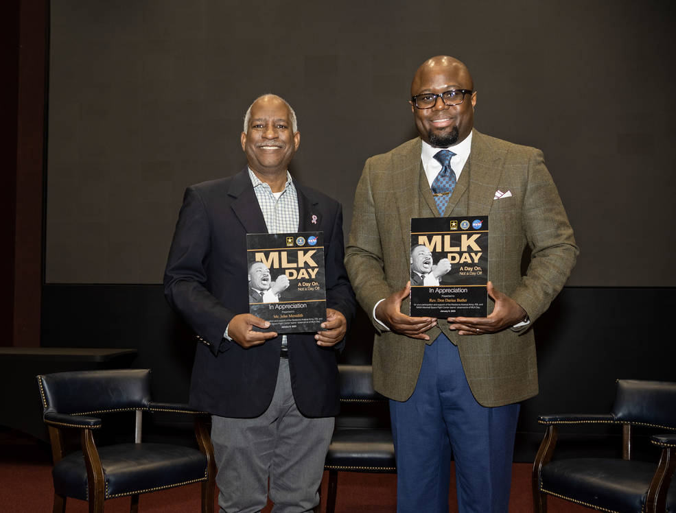 Two men in suits hold a MLK appreciation plaque after being the keynote speakers for 2023 Martin Luther King Jr. Day event.