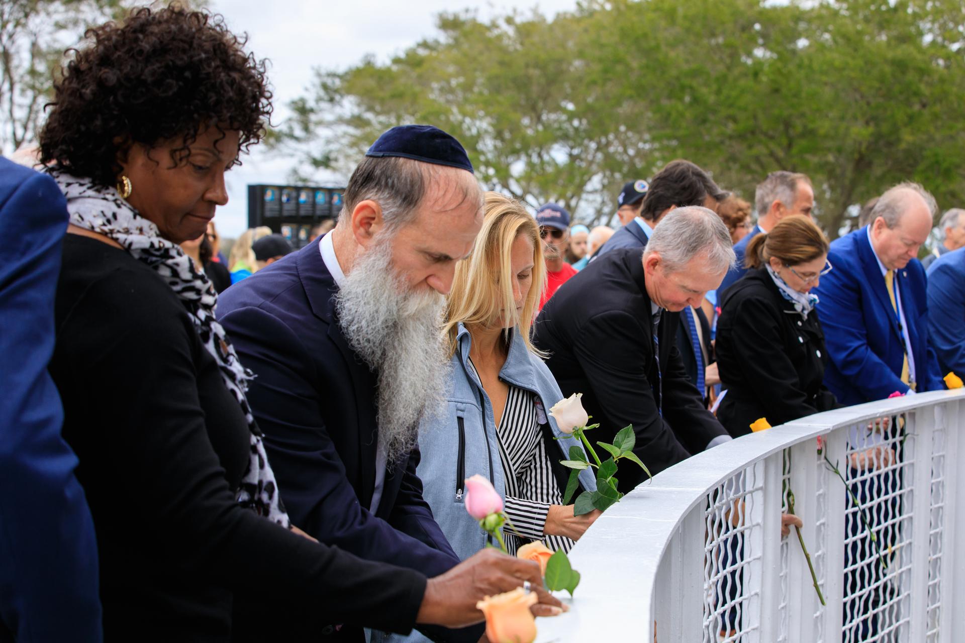 Kennedy Space Center workers and guests place flowers at the Space Mirror Memorial at the Kennedy Space Center Visitor Complex in Florida during the Day of Remembrance on Jan. 26, 2023. 