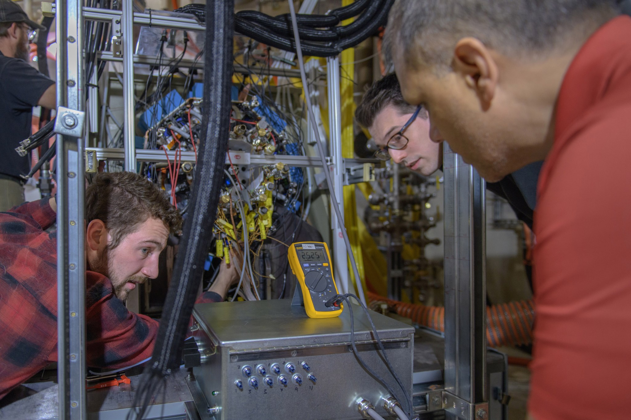 Ohio State Graduate Research Assistant Alec Schnabel (left), University of Wisconsin doctoral candidate James Swanke (center), and Ohio State Graduate Research Engineer Robert Borjas conduct tests on aircraft hardware at NEAT