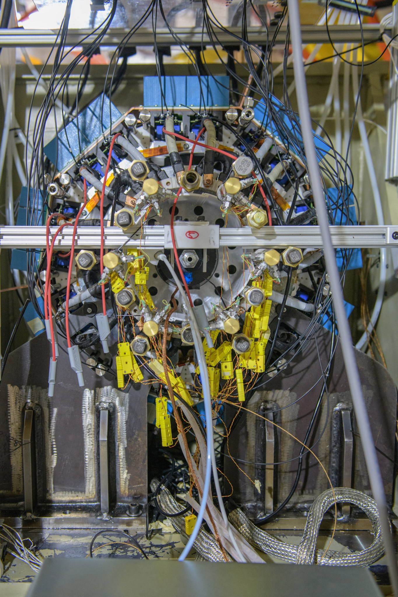 Large motor mounted inside a testing unit with colorful blue and yellow wires.