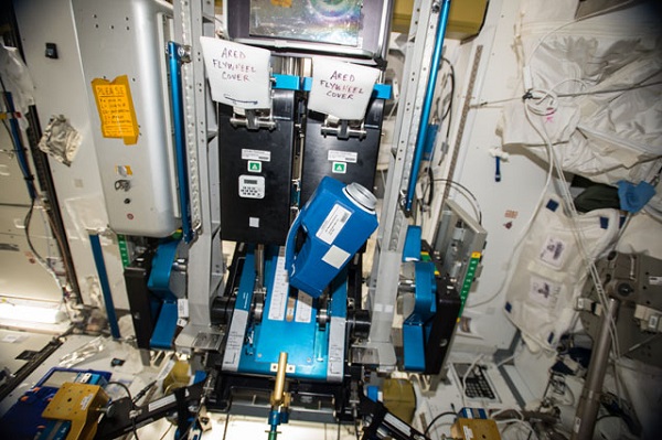 image of a sample collector floating in the space station