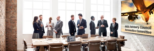 Stock imagery of a meeting room with a team of people. On the wall is a large art print that says NASA Advisory Council Aeronautics Committee