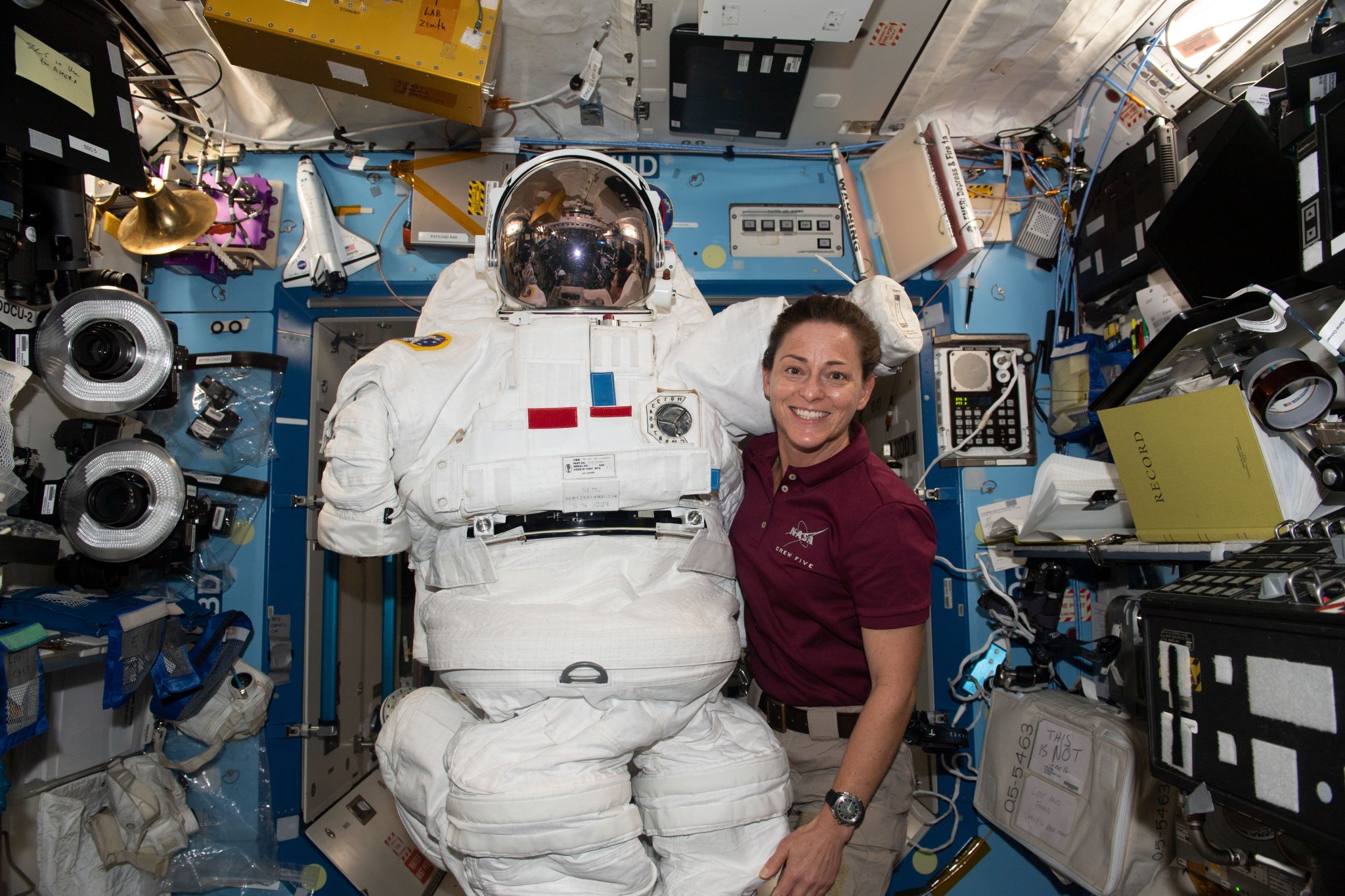 (Dec. 28, 2022) u002du002d- Expedition 68 Flight Engineer and NASA astronaut Nicole Mann poses with an Extravehicular Mobility Unit (EMU), also known as a spacesuit, aboard the International Space Station.