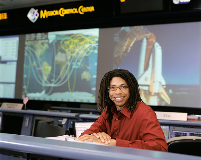 A Student in a red shirt sitting in Mission Control Center
