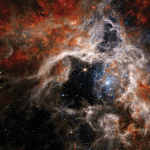 Space image with stars and swirls of colorful orange, red and white.