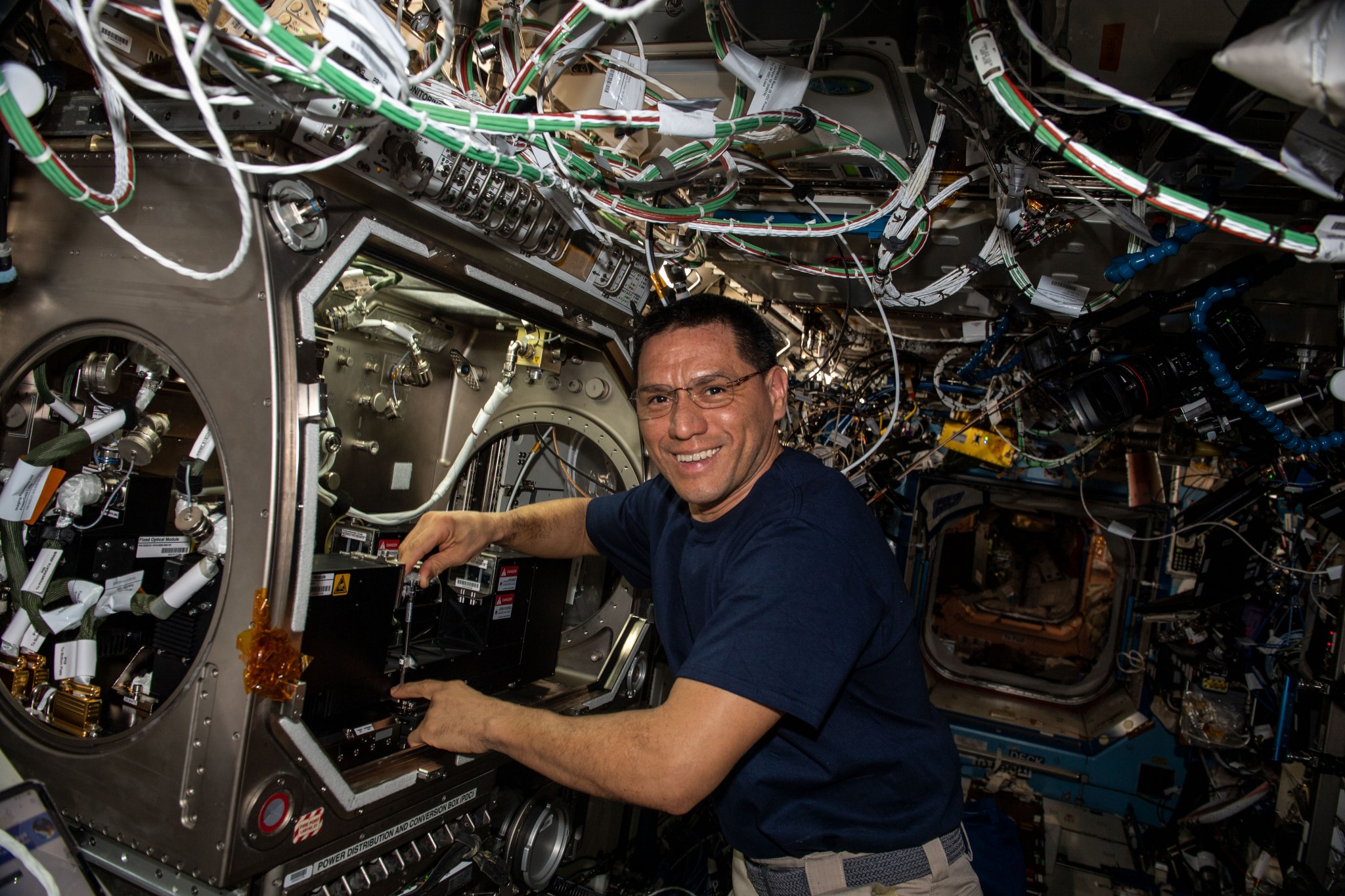 image of an astronaut installing experiment hardware