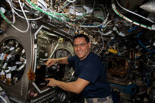 imagen de un astronauta instalando hardware de un experimento
